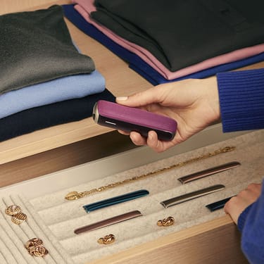 user-pulling-ploom-aura-dark-orchid-device-out-of-drawer