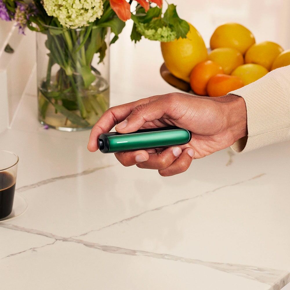 Hand holding a Ploom device with Amazon Green Front Panel