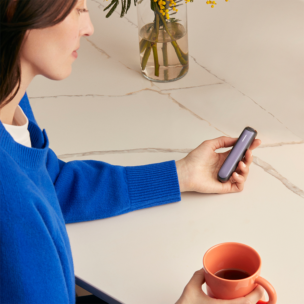 Woman holding a Ploom device with Lavender Front Panel