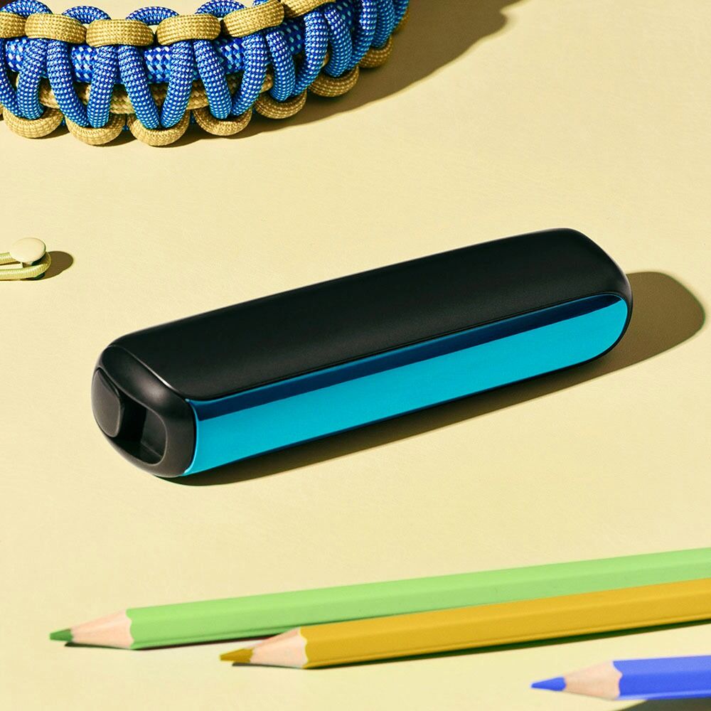 Close-up of a Ploom AURA front panel Ocean Blue accessory on a desk.