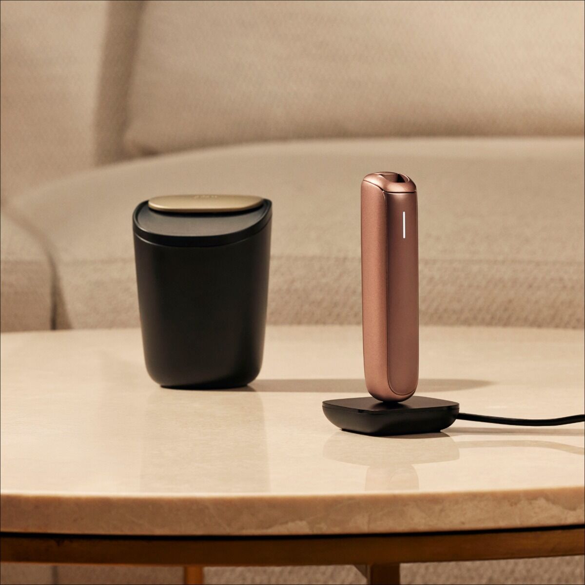 Ploom Large Stick Tray next to charging Plooom AURA device